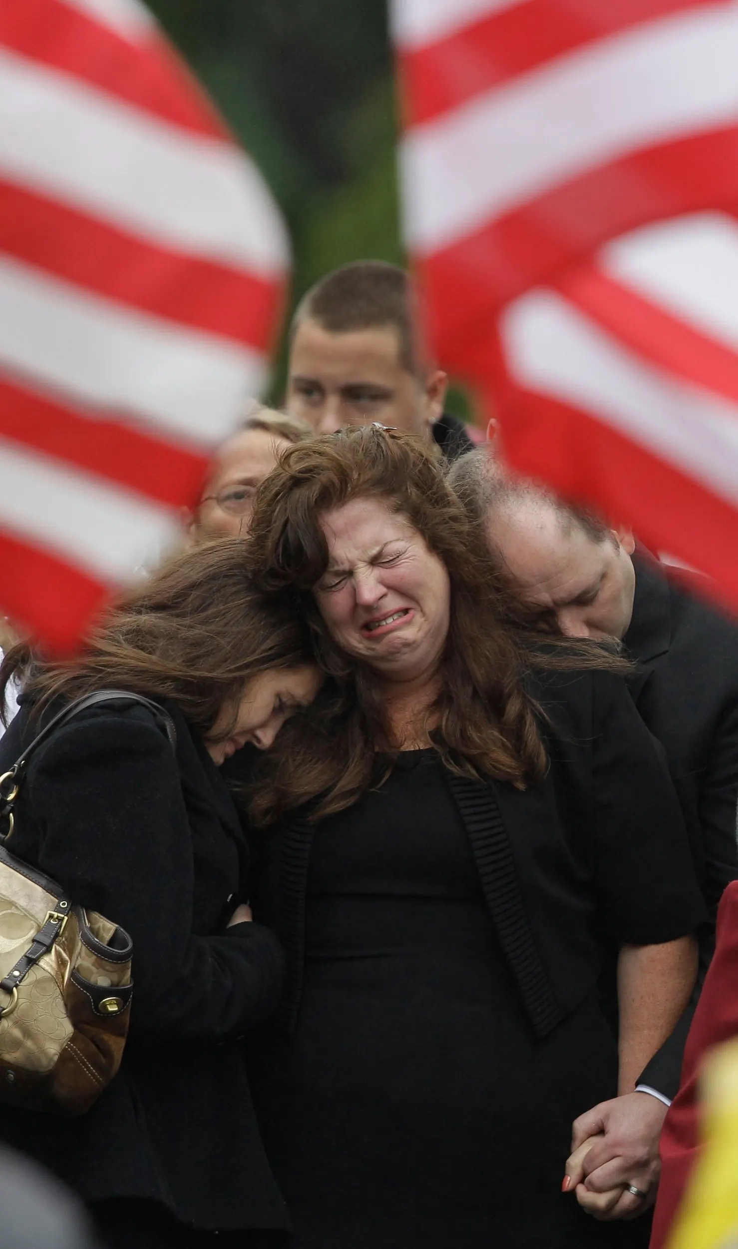 A Private's Funeral — Kathleen Lumsden, center, mother of Army Private 1st Class Clinton E. Springer II, hugs her son's girlfriend Kalie Masse outside St. Patrick's Church in Falmouth, Massachsutts, on Tuesday, October 5, 2010. Springer, 21, was killed in a noncombat incident in Kabul, Afghanistan in September.  (AP Photo/Stephan Savoia)  © The Associated Press
