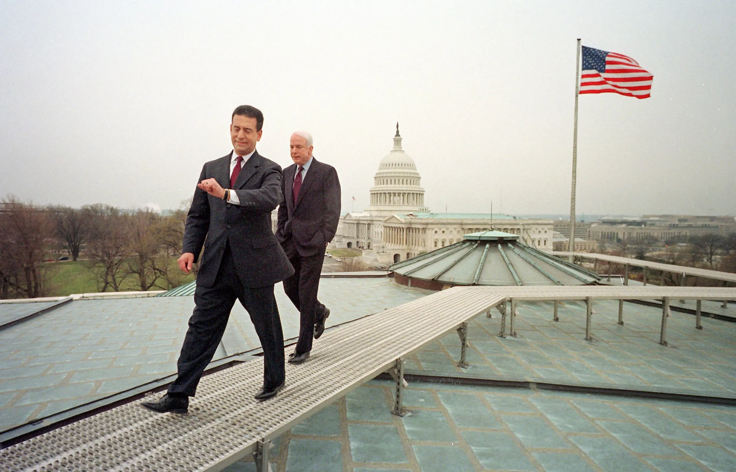 Moving Into A Transient Future — U.S. Senator Russ Feingold, Democrat Wisconsin, checks his watch as he and Senator John McCain, Republican Arizona, walk off the roof of the Russell office building on Capitol Hill after a morning Time Magazine photo session Thursday, March 29, 2001 in Washington, D.C. Feingold and McCain enjoyed a major victory later that day during the debate over their campaign finance reform bill as the Senate voted to table a non-survivability amendment clearing the way for the bill's passage. The United States Supreme Court overturned the McCain Feingold Act with their 2010 Citizens United decision.  (AP Photo/Stephan Savoia)  © The Associated Press