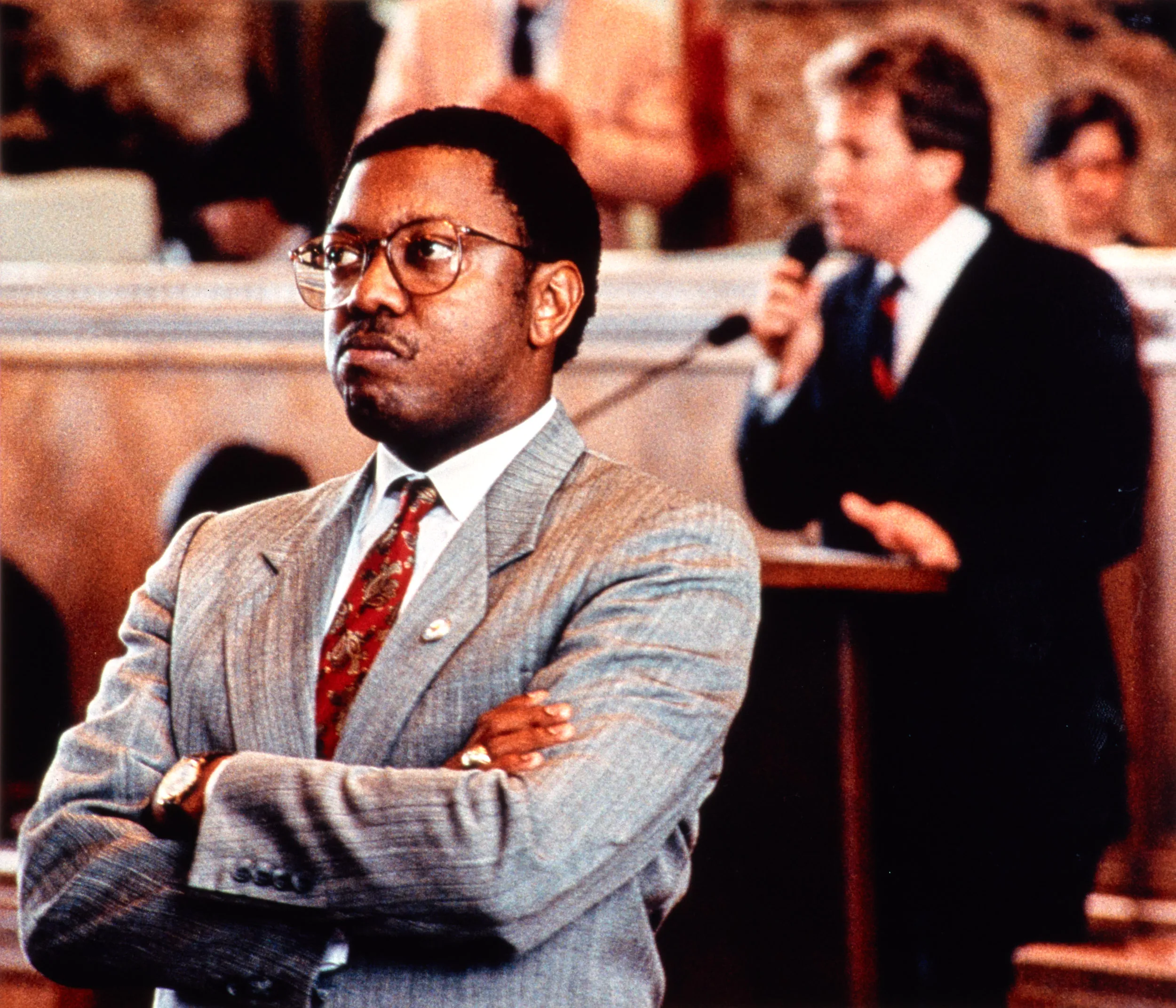 Silent Protest — Representative Kip Holden, Democrat Baton Rouge, leader of the Black Caucus in the Louisiana House of Representatives stands with his back turned away from the chamber's rostrum in protest of former Ku Klux Klan Grand Wizard and newly elected representative to the Louisiana House of Representatives, Republican David Duke, on May 31, 1990. Duke takes a point of personal privilege to condemn Louisiana Governor Buddy Roemer’s statement concerning his veto of Duke’s bill outlawing state affirmative action programs. Holden was joined by the chamber’s entire Black Caucus membership in his rebuke of Duke.  (Photo by Stephan Savoia)  Published by The Baton Rouge Louisiana State-Times & Morning Advocate