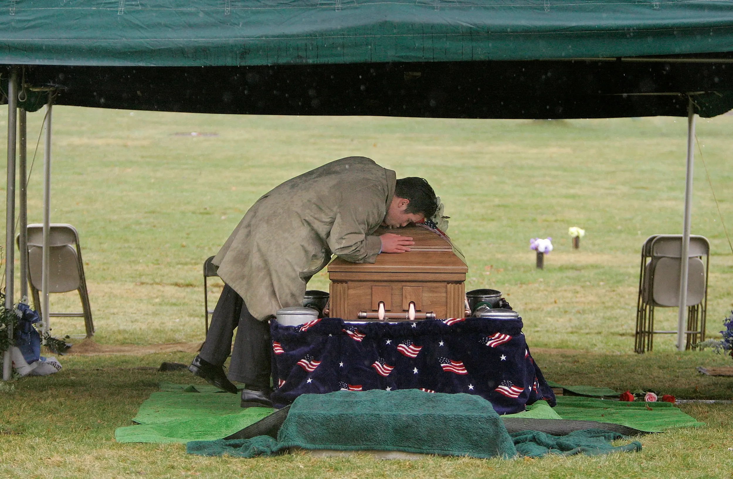 Goodbye Kiss — During a steady rain, Colin Kennedy, youngest brother of Army Sgt. Adam Kennedy, kisses Adam goodbye after everyone else left the grave site in Canton, Massachusetts, Tuesday afternoon, April 17, 2007. Kennedy, 25, was killed on Sunday, April 8, 2007 by the blast from an improvised explosive device south of Baghdad, Iraq.  (AP Photo/Stephan Savoia)  © The Associated Press
