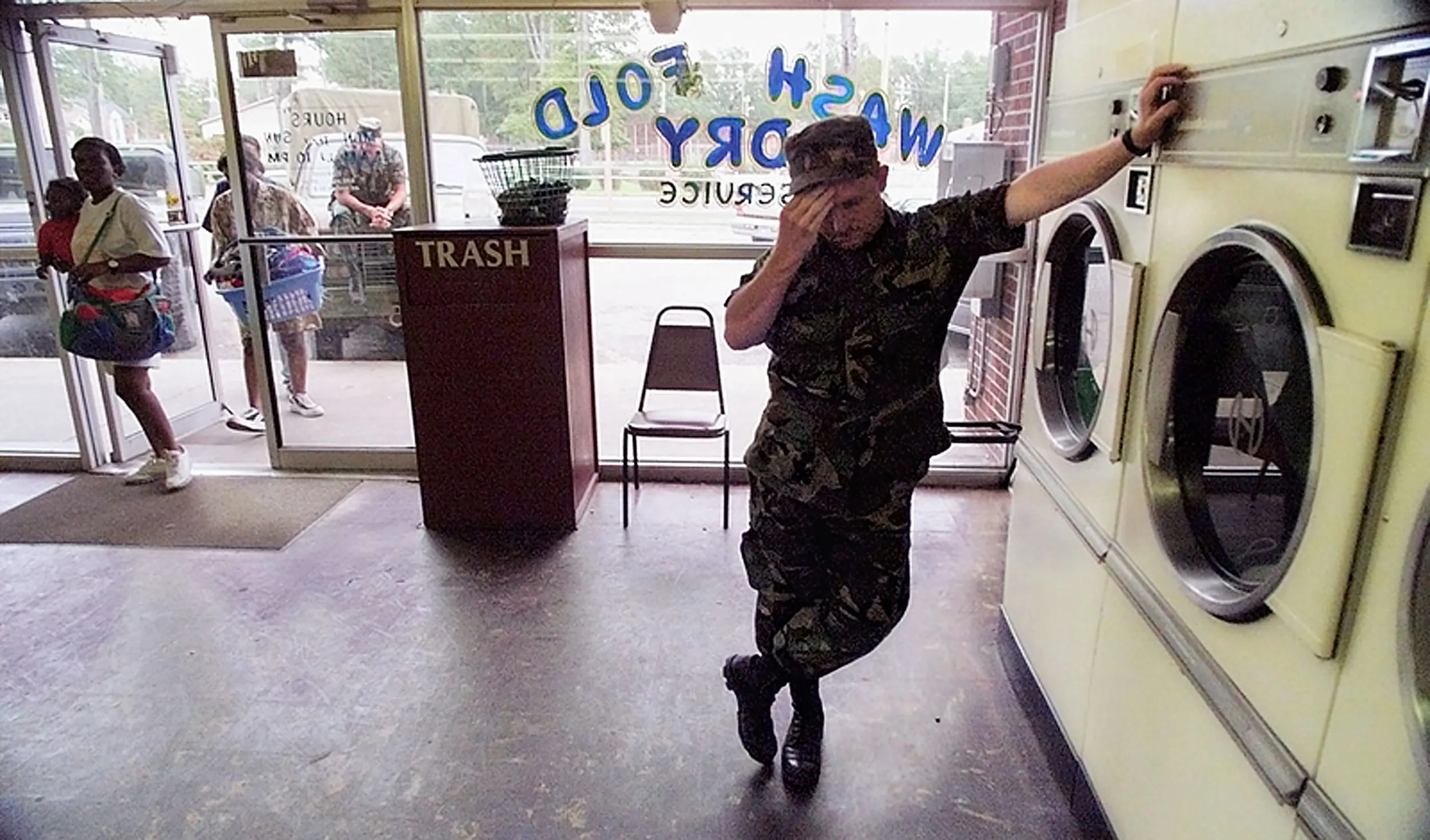 Flood Fatigue — National Guardsman Eddy Langston rubs his head as he leans on a dryer in a Kinston, North Carolina, coin-operated laundry waiting for his clothes to dry Friday afternoon, September 24, 1999. Langston, from Dunn, North Carolina, and his company were called up to staff flood relief efforts for seven days last Monday. Today they were informed their tour has been extended.  (AP Photo/Stephan Savoia)  © The Associated Press