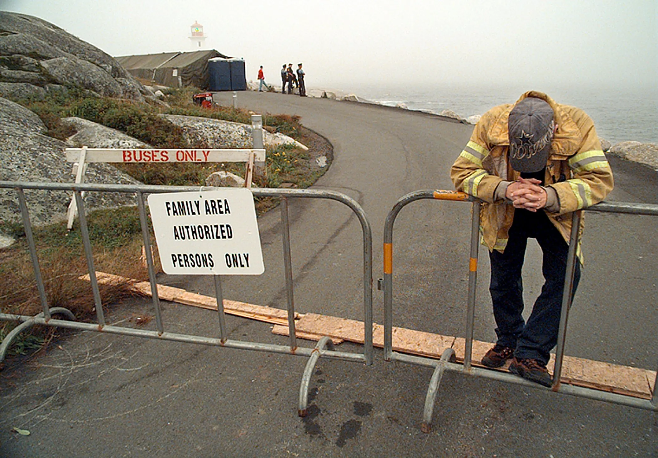 Mourning — A volunteer fireman, preferring not to offer his name, stands guard near a tent pitched for family members of crash victims aboard Swissair Flight 111 who choose to visit Peggy's Cove, Nova Scotia, Canada, on Friday evening, September 4, 1998. Flight 111 went down late Wednesday evening, September 2, 1998, in the Atlantic Ocean some five miles offshore, killing all 229 souls aboard.  (AP Photo/Stephan Savoia)  © The Associated Press