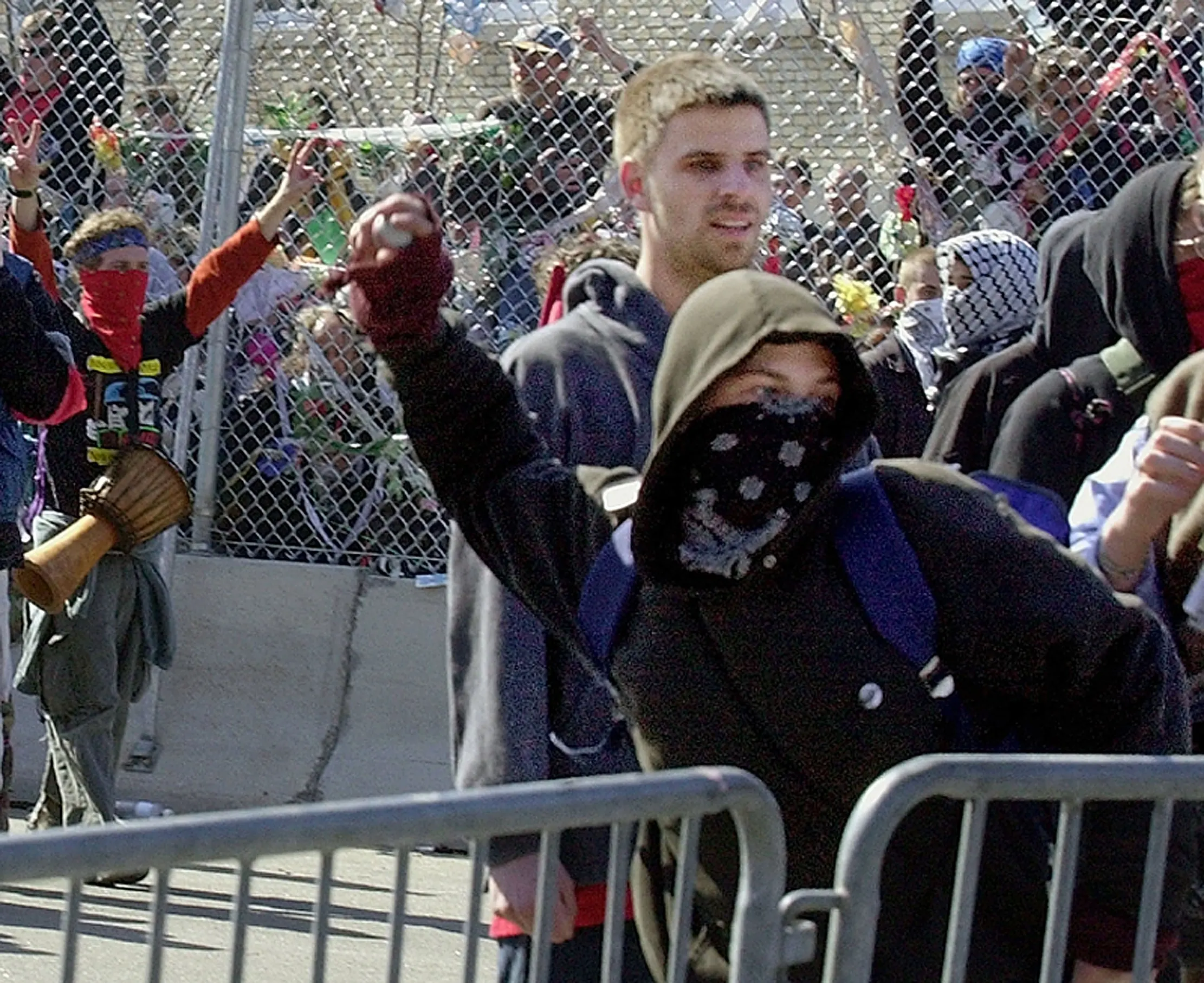 A Rioter's Windup — A protester throws a golf ball at police after the security fence surrounding the Summit of the Americas in Quebec City, Canada, was breached on Friday afternoon, April 20, 2001. Confrontations between police and protesters ensued after the fence came down as the Summit, where 34 heads of state from the western hemisphere gathered to discuss trade issues, got underway.  (AP Photo/Stephan Savoia)  © The Associated Press