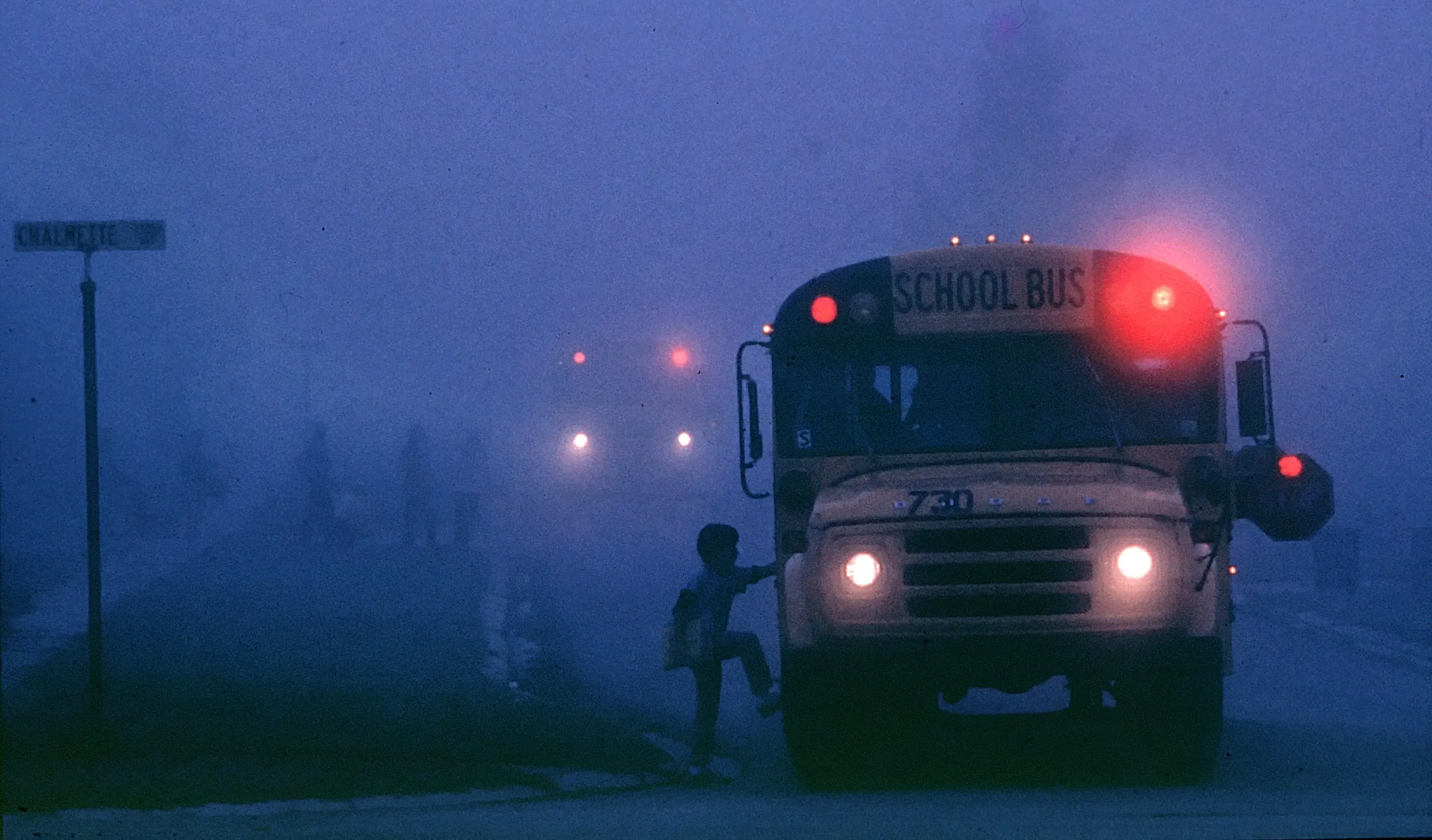 Bayou Country Fog — School buses pick up students in a heavy South Louisiana early morning fog on the outskirts of Baton Rouge, Louisiana.  (Photo by Stephan Savoia)  Published by The Baton Rouge Louisiana State-Times & Morning Advocate Circa Mid 1980s
